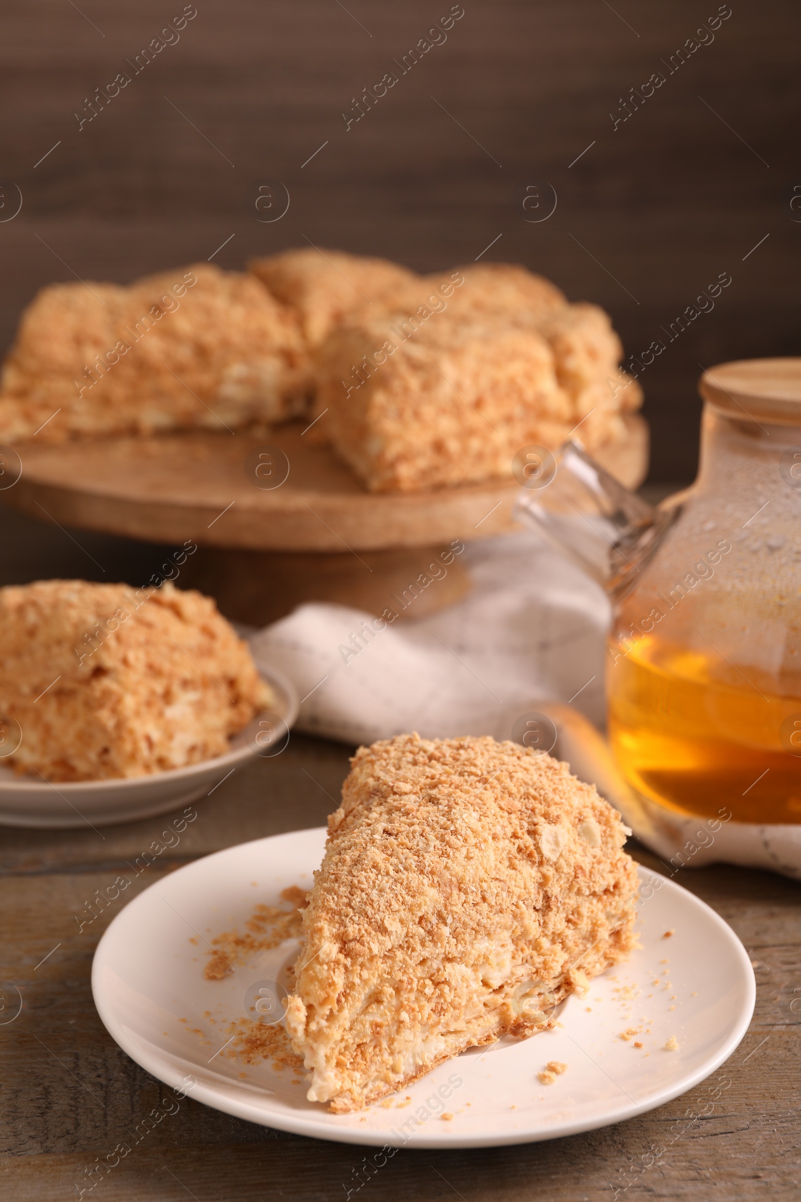 Photo of Piece of delicious Napoleon cake served on table, closeup