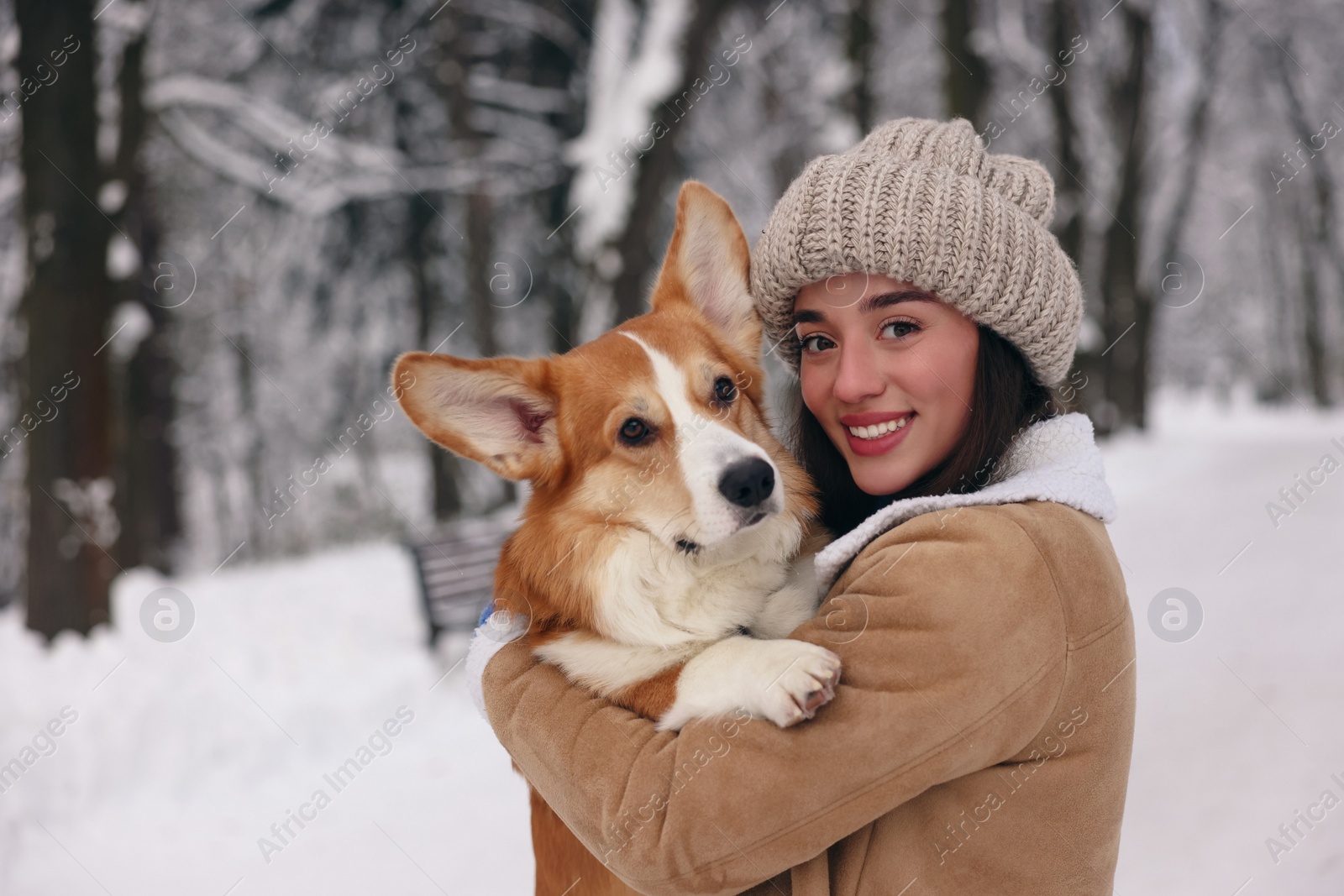 Photo of Woman with adorable Pembroke Welsh Corgi dog in snowy park