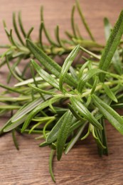 Photo of Fresh green rosemary on wooden table, closeup