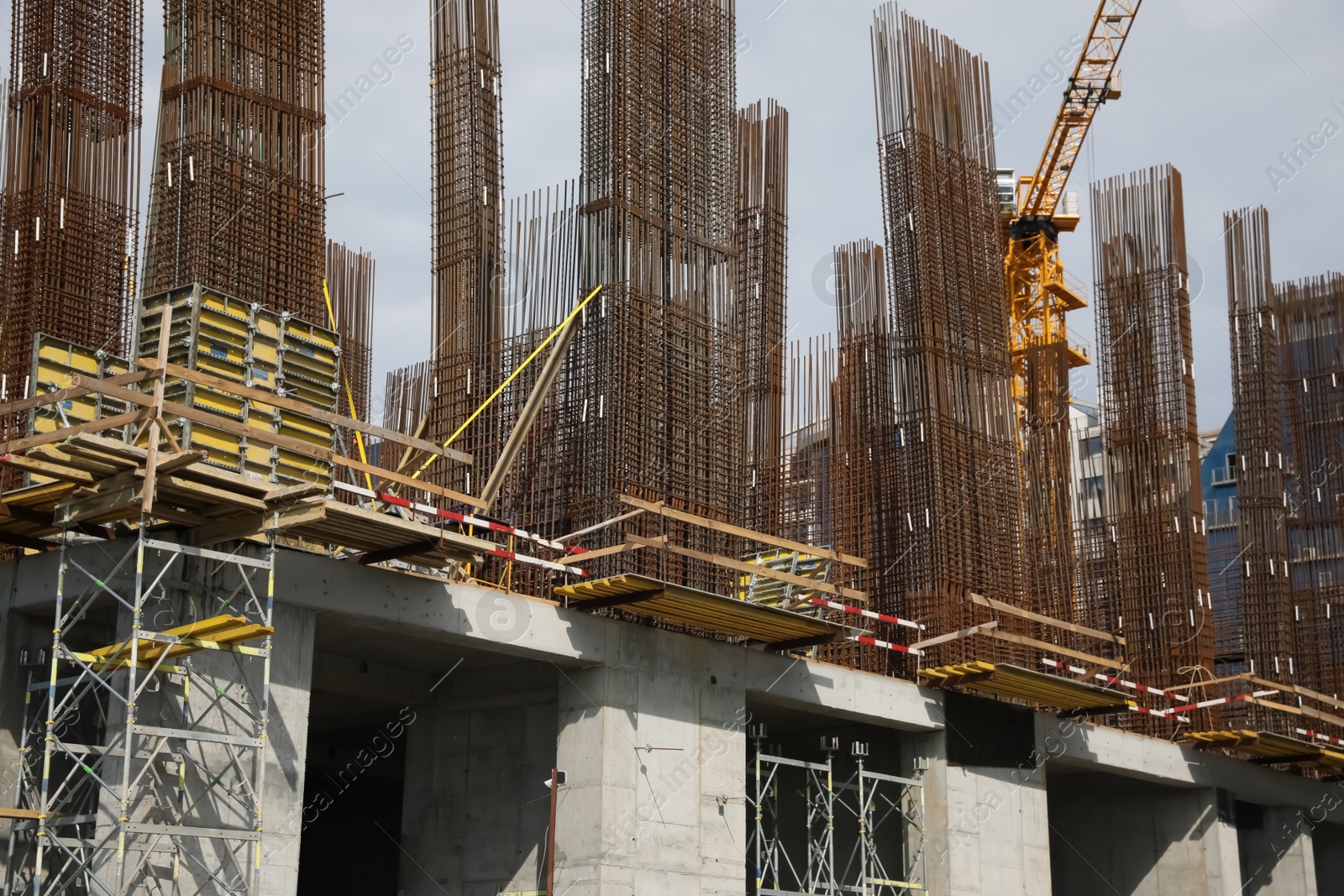 Photo of Tower crane near building under construction on sunny day