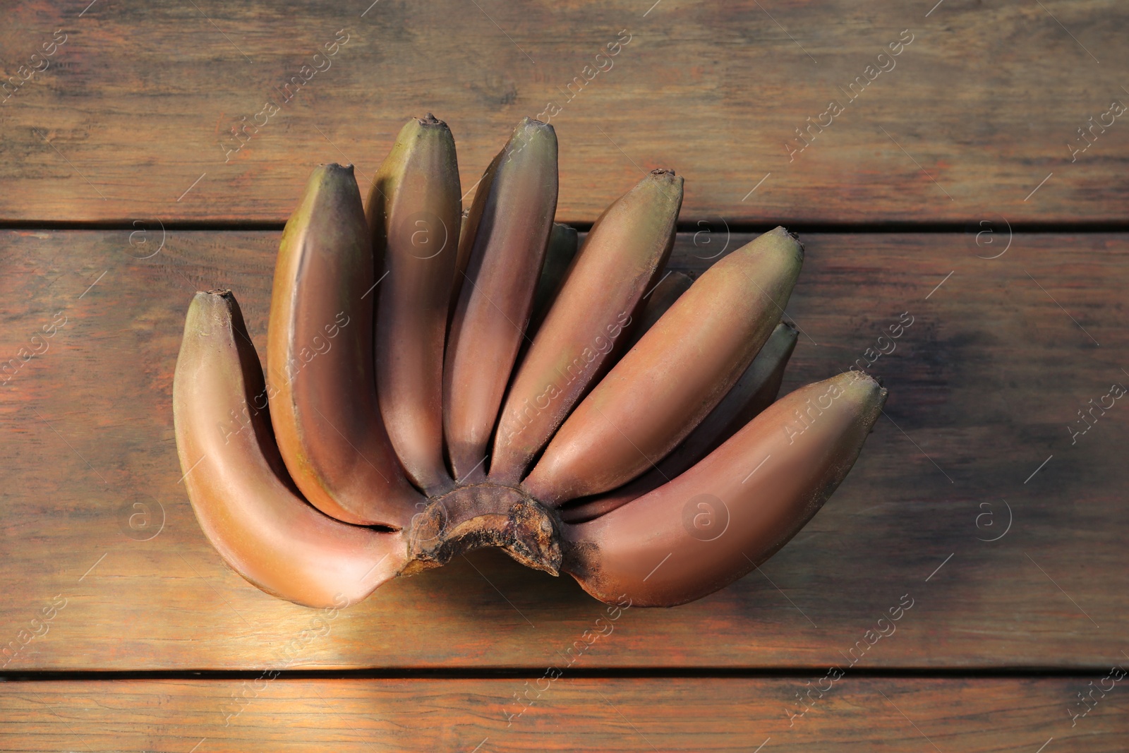 Photo of Tasty purple bananas on wooden table, top view