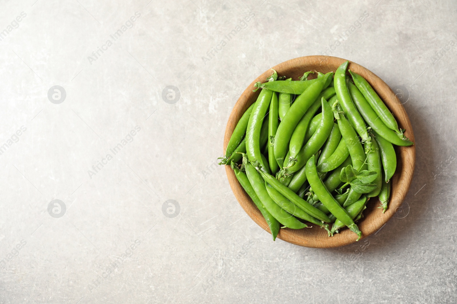 Photo of Plate with green peas on light background, top view