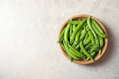 Photo of Plate with green peas on light background, top view