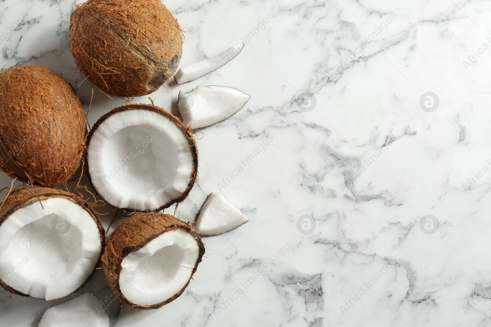 Photo of Flat lay composition with coconuts a on marble table. Space for text