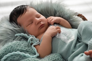 Photo of Cute newborn baby sleeping in wicker basket, closeup