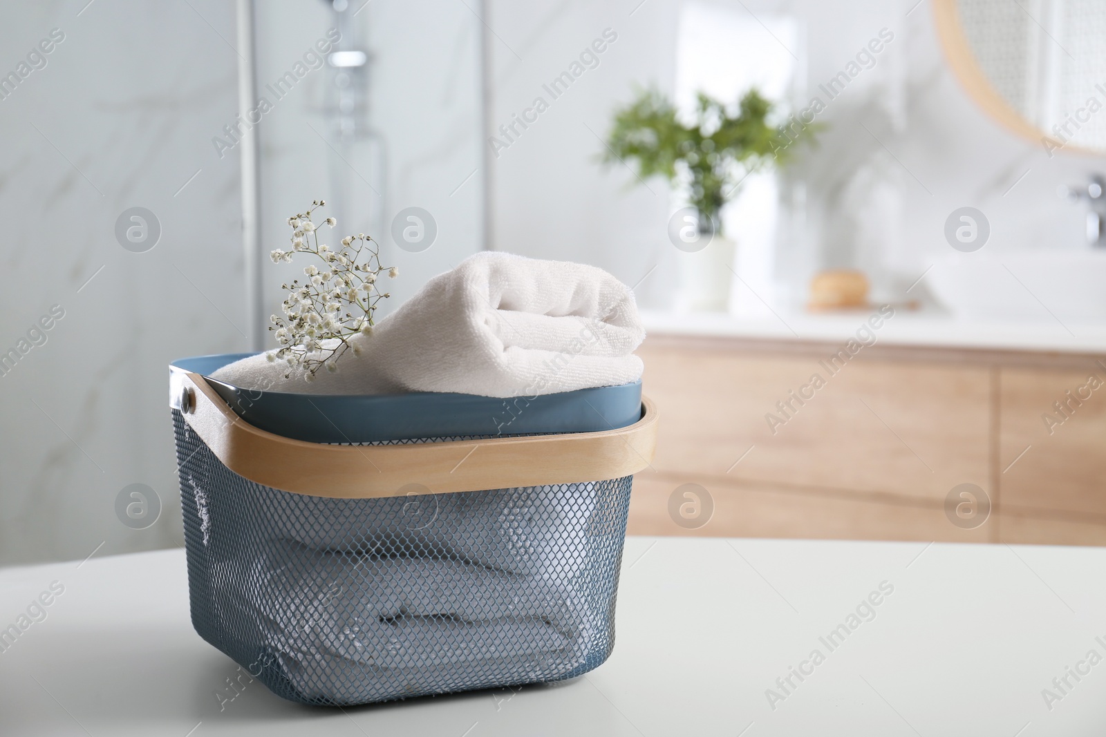 Photo of Basket with clean soft towels in bathroom. Space for text