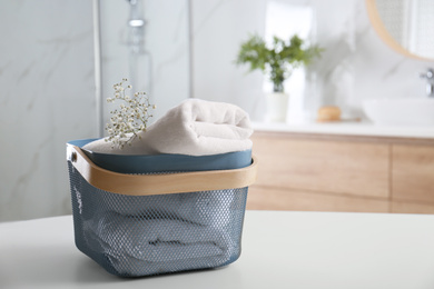 Basket with clean soft towels in bathroom. Space for text