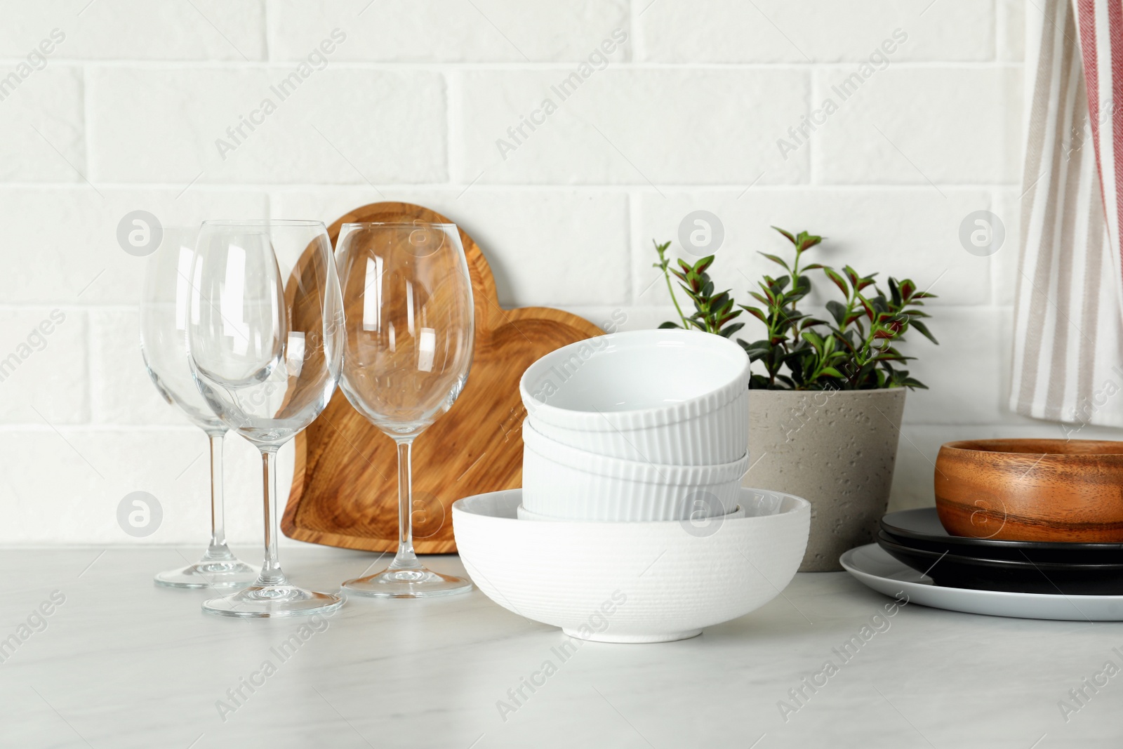 Photo of Set of clean tableware on white countertop in kitchen