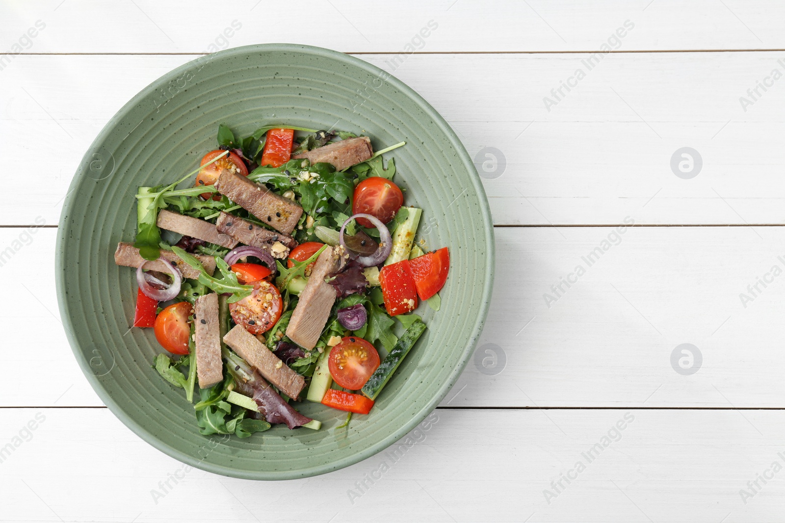 Photo of Delicious salad with beef tongue and vegetables on white wooden table, top view. Space for text