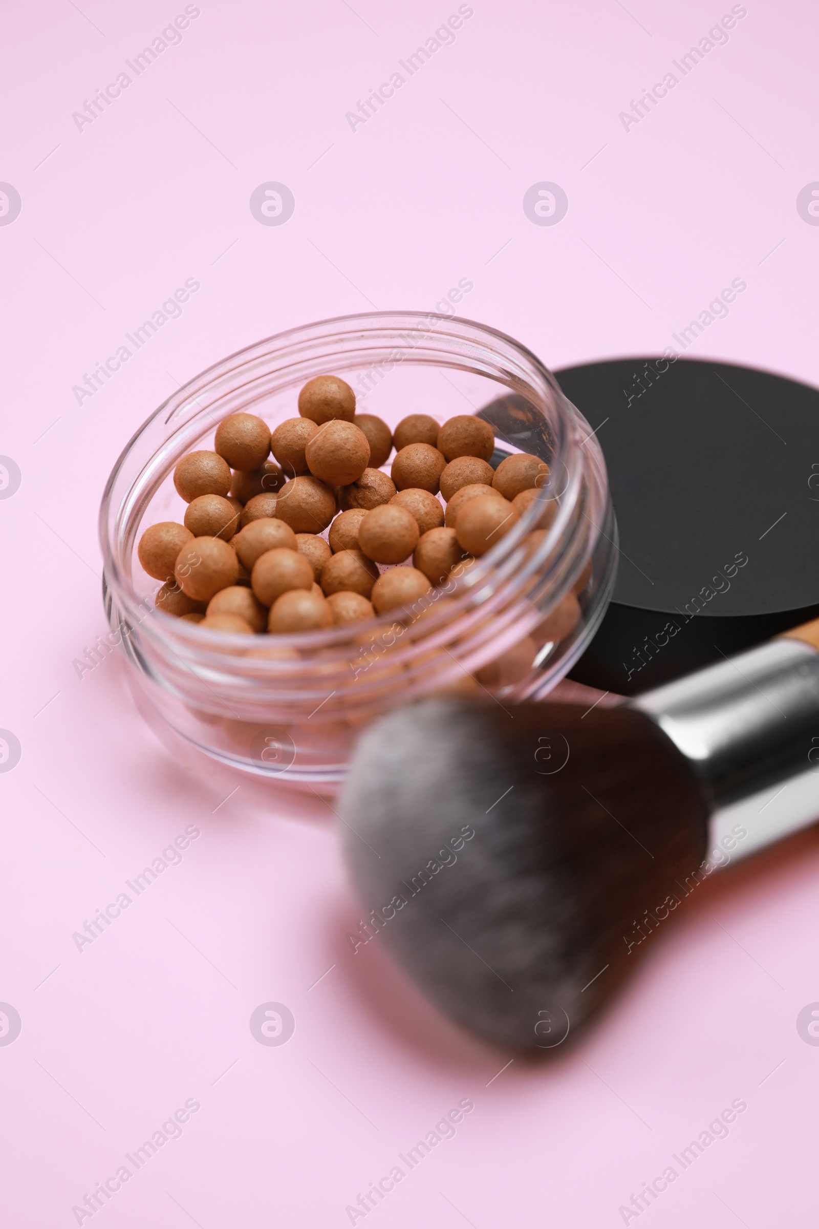 Photo of Face powder balls and brush on pink background