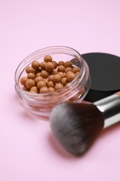 Photo of Face powder balls and brush on pink background
