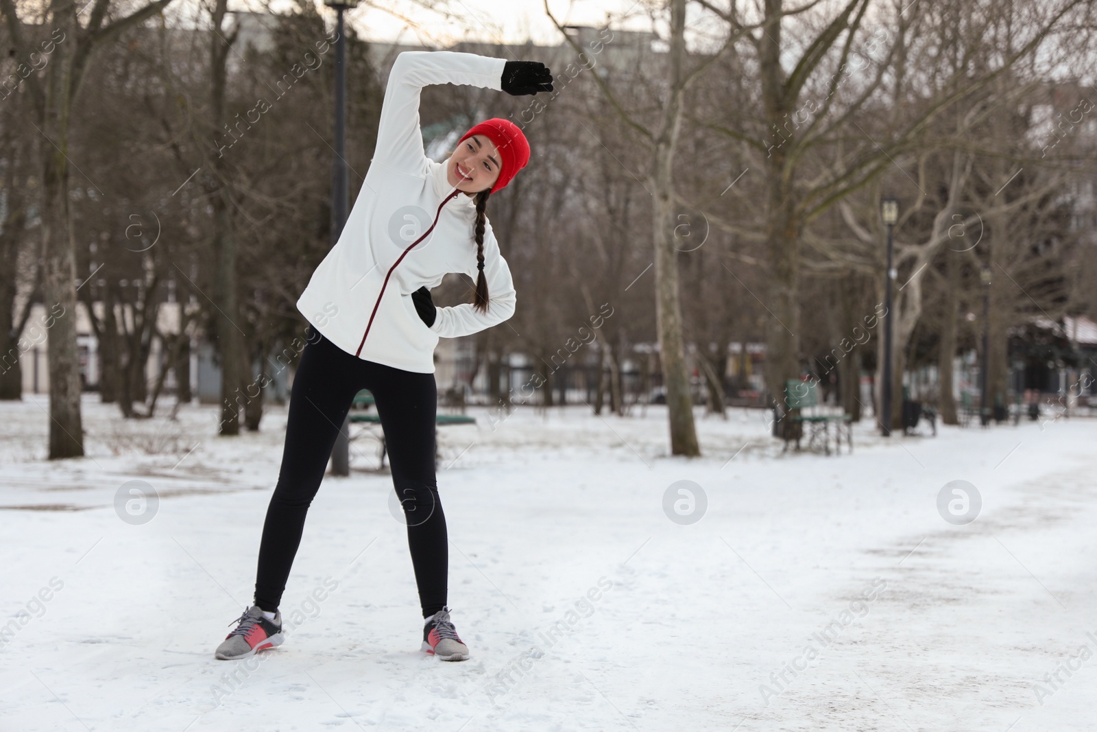 Photo of Woman doing sports exercises in winter park