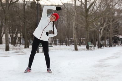 Photo of Woman doing sports exercises in winter park