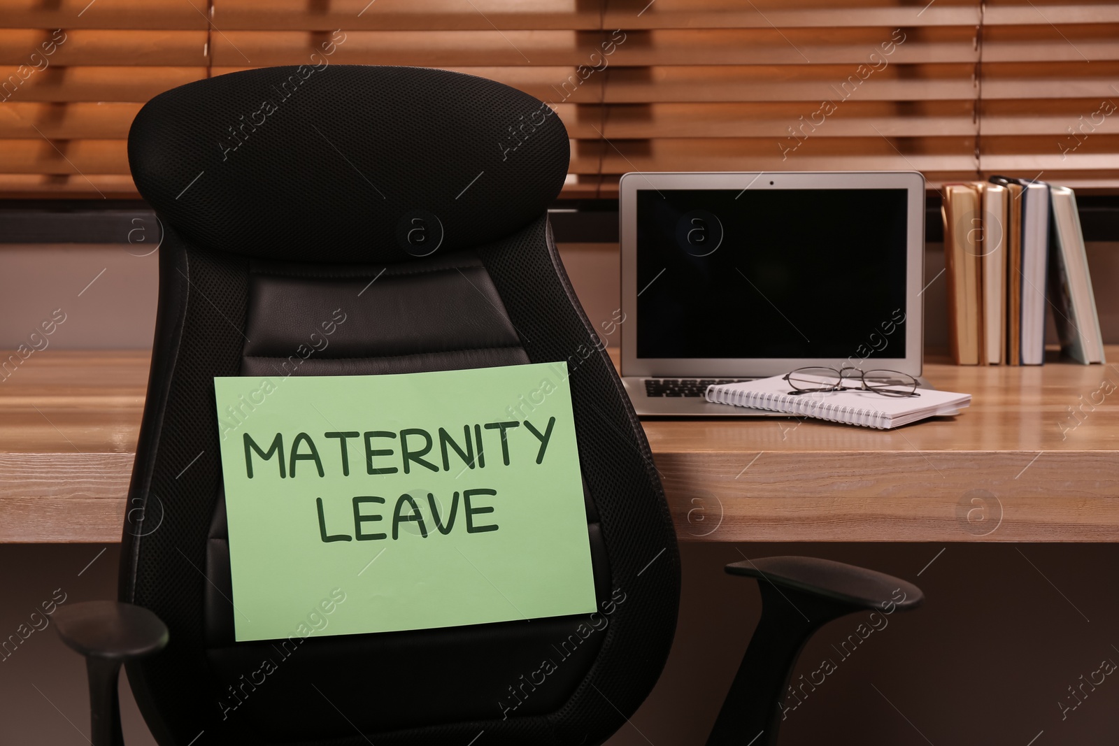 Photo of Note with text Maternity Leave on office chair back near workplace indoors