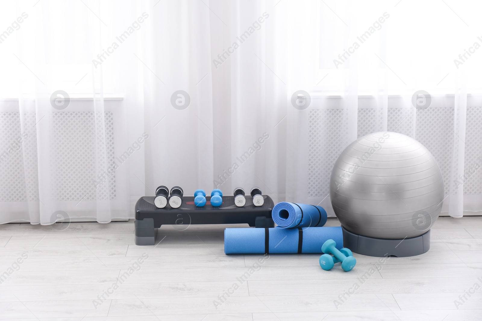 Photo of Different sports equipment near window in gym. Space for text