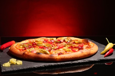 Photo of Delicious pizza Diablo on slate board against red background