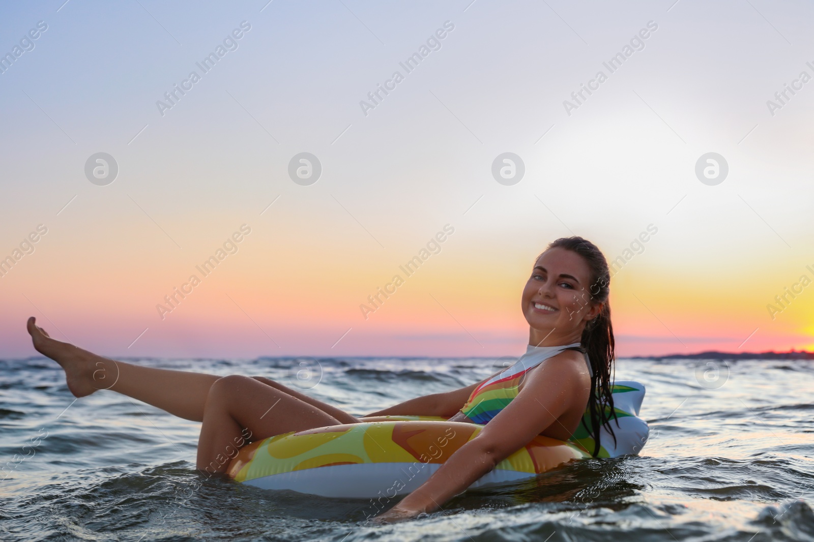 Photo of Young woman on inflatable ring in water