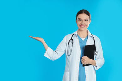 Photo of Doctor with stethoscope and clipboard on blue background