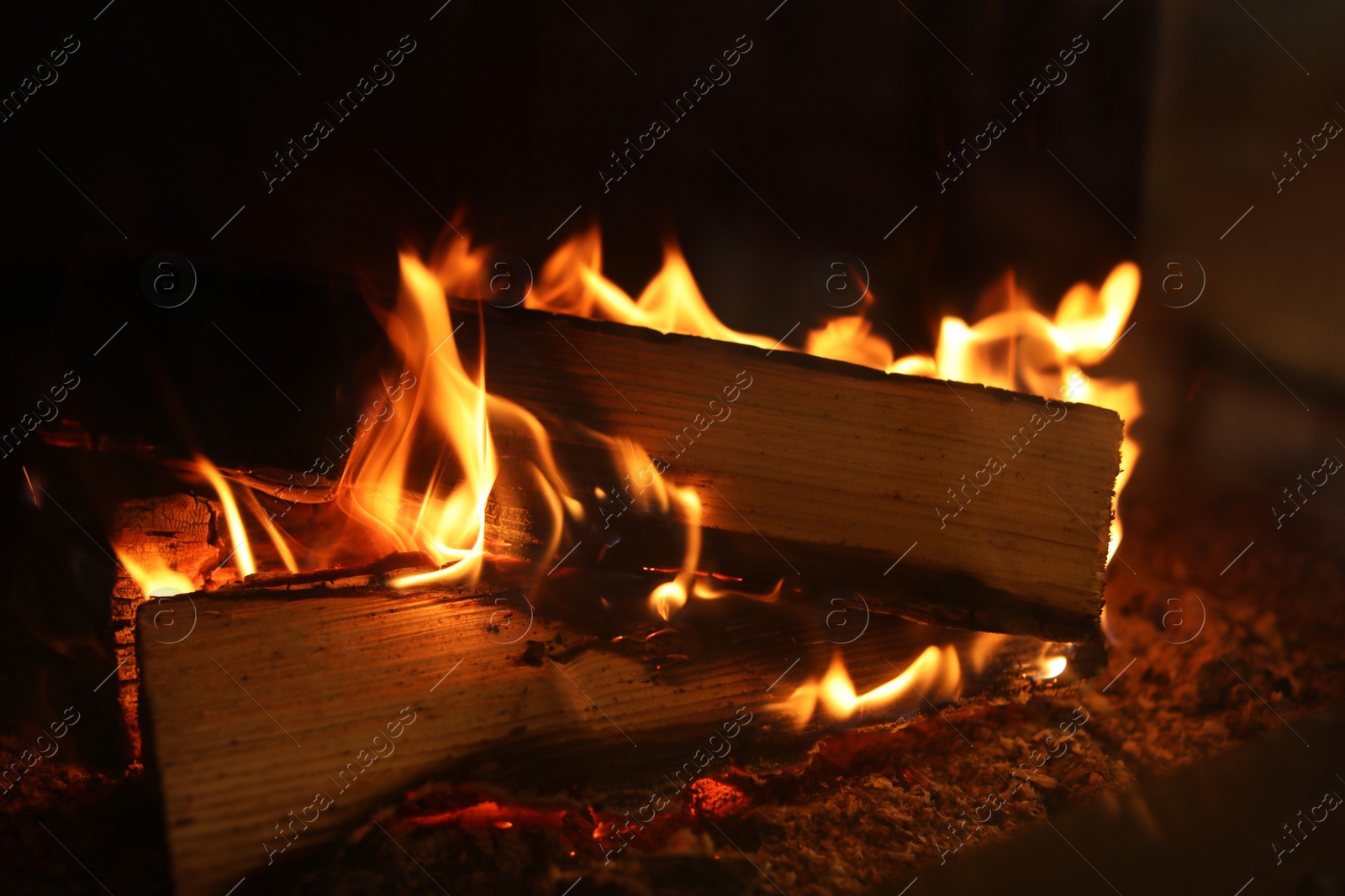 Photo of Fireplace with burning wood, closeup view. Winter vacation