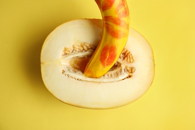 Photo of Flat lay composition with fresh banana and melon on yellow background. Sex concept