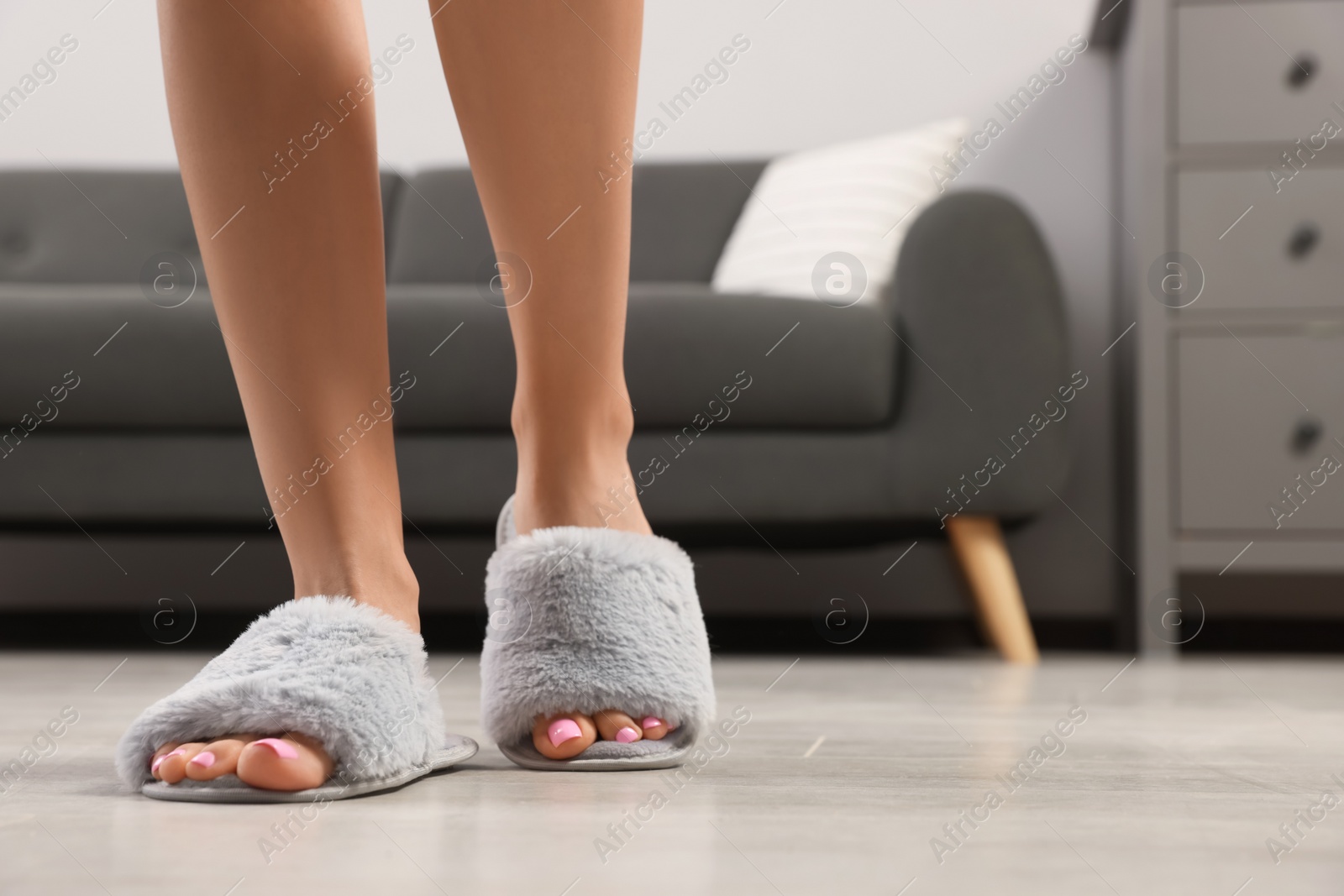 Photo of Woman wearing grey soft slippers at home, closeup