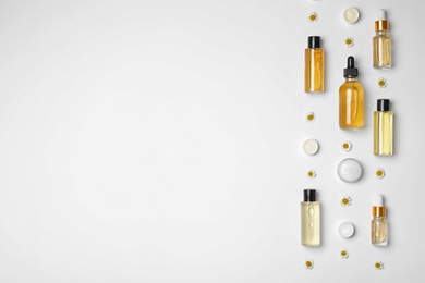 Flat lay composition with chamomiles and cosmetic products on white background. Space for text