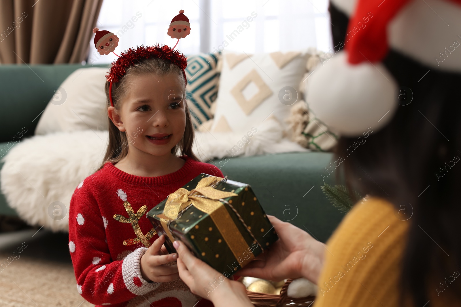 Photo of Mother and daughter with gift box at home. Christmas celebration