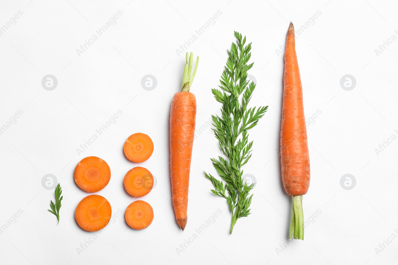 Photo of Tasty ripe carrots and leaves isolated on white, top view