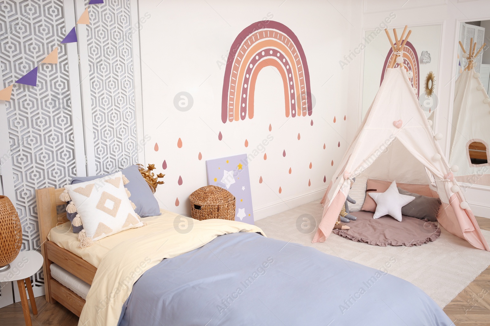 Photo of Stylish room with comfortable bed and teepee tent for kids. Interior design