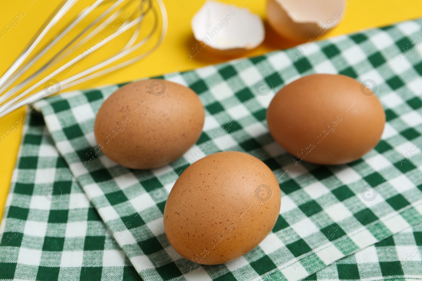 Photo of Chicken eggs on checkered kitchen towel, closeup