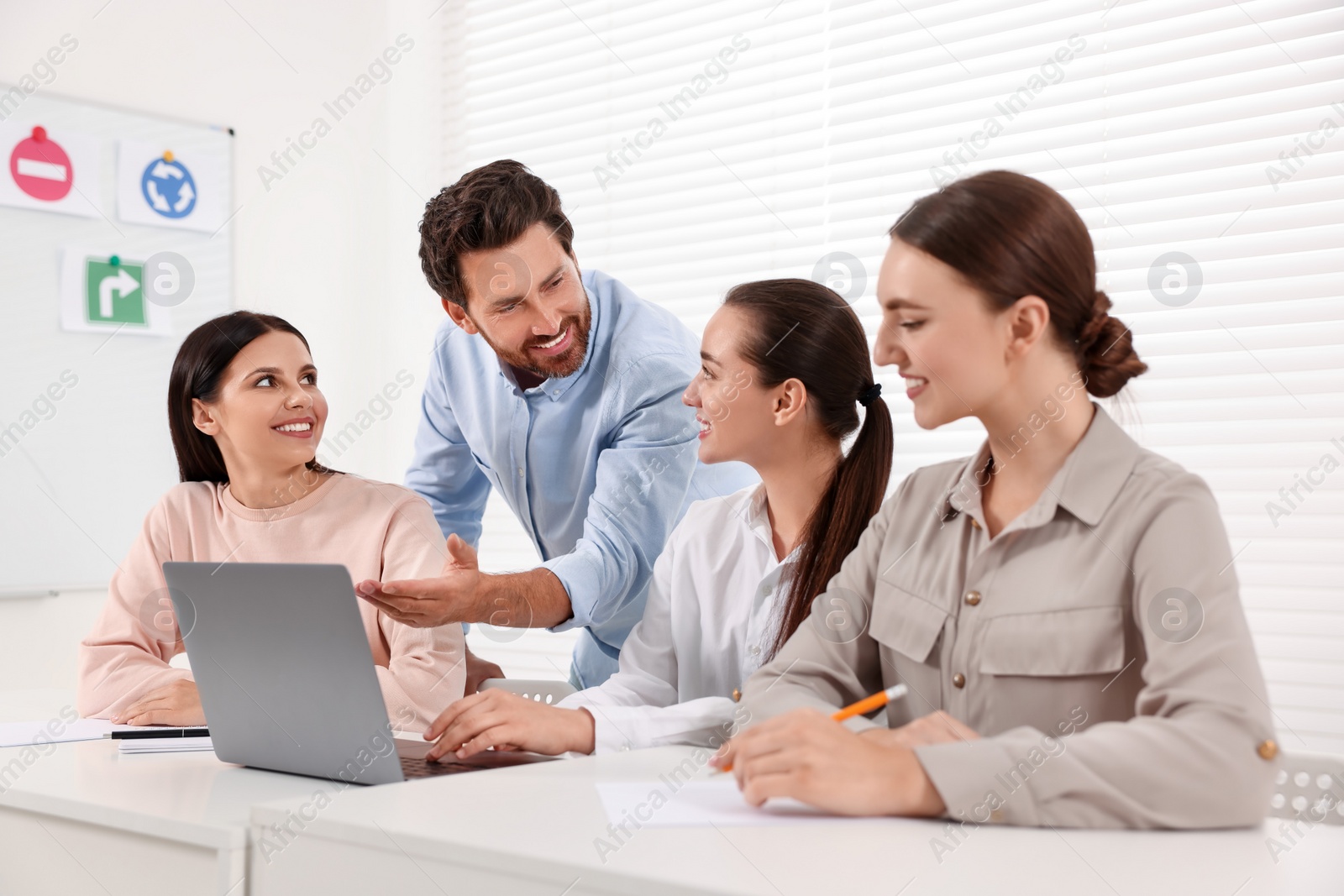 Photo of Happy teacher giving lesson in driving school