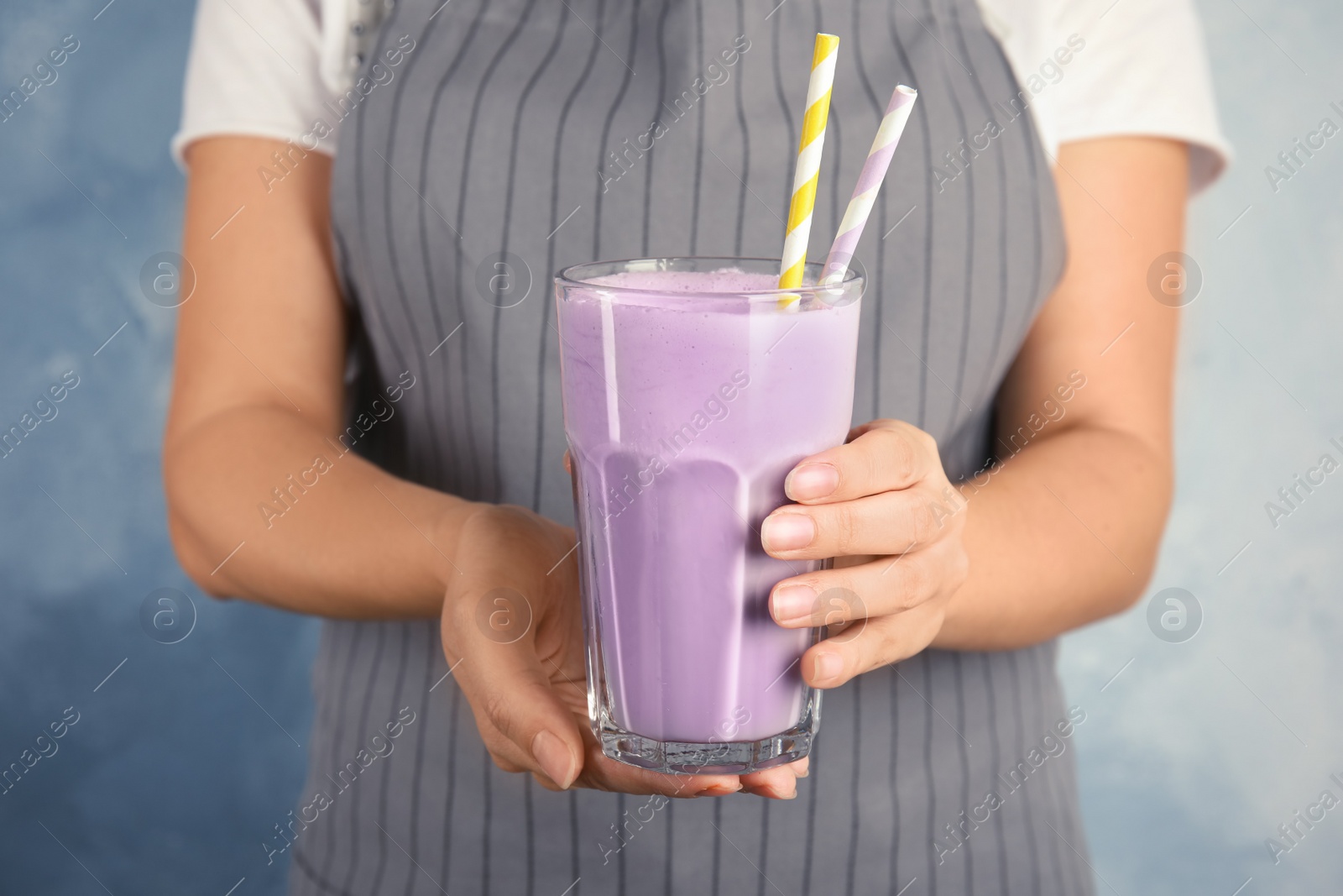 Photo of Woman with glass of delicious milk shake on color background, closeup