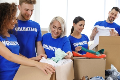 Team of volunteers collecting donations in boxes indoors