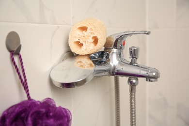 Photo of Purple shower puff and loofah sponge in bathroom