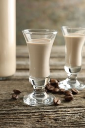 Coffee cream liqueur in glasses and beans on wooden table