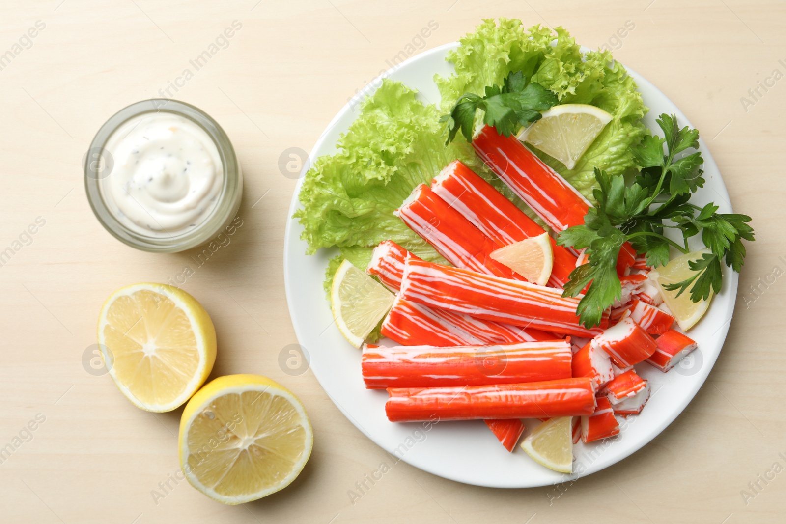 Photo of Delicious crab sticks served on wooden table, flat lay