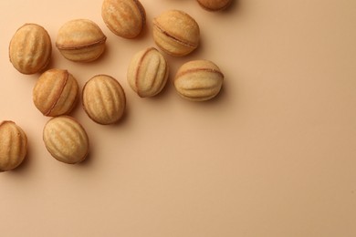 Photo of Homemade walnut shaped cookies with condensed milk on beige background, flat lay. Space for text