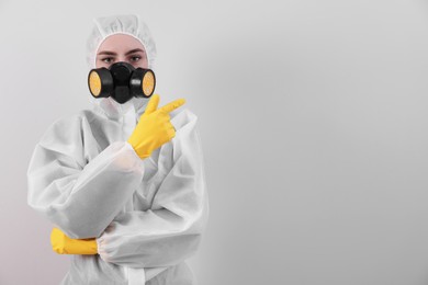 Woman in protective suit pointing at mold on wall. Space for text