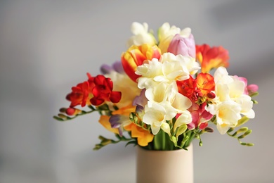 Beautiful bouquet of freesia flowers on blurred background