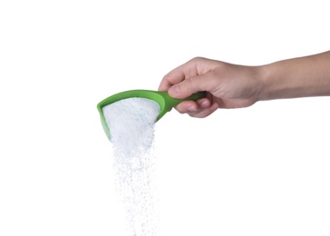 Photo of Woman pouring laundry detergent from measuring container against white background, closeup