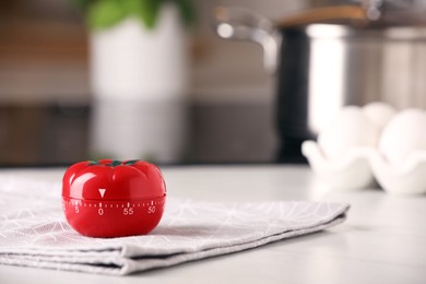 Photo of Kitchen timer in shape of tomato on white table indoors. Space for text