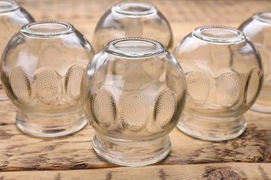 Photo of Glass cups on wooden table, closeup. Cupping therapy