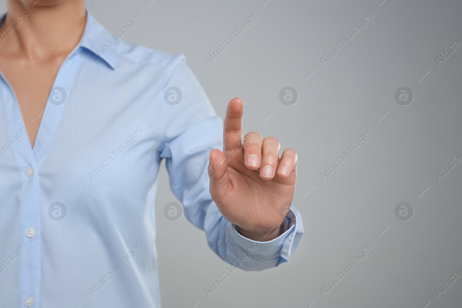 Photo of Woman touching something against grey background, focus on hand