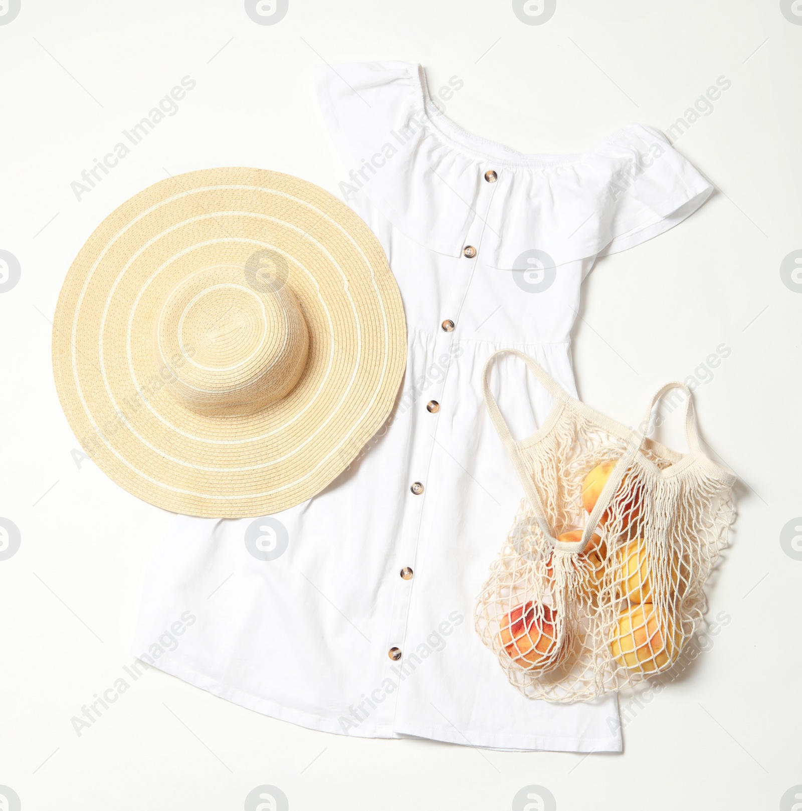 Photo of Stylish dress, hat and peaches on white background, flat lay