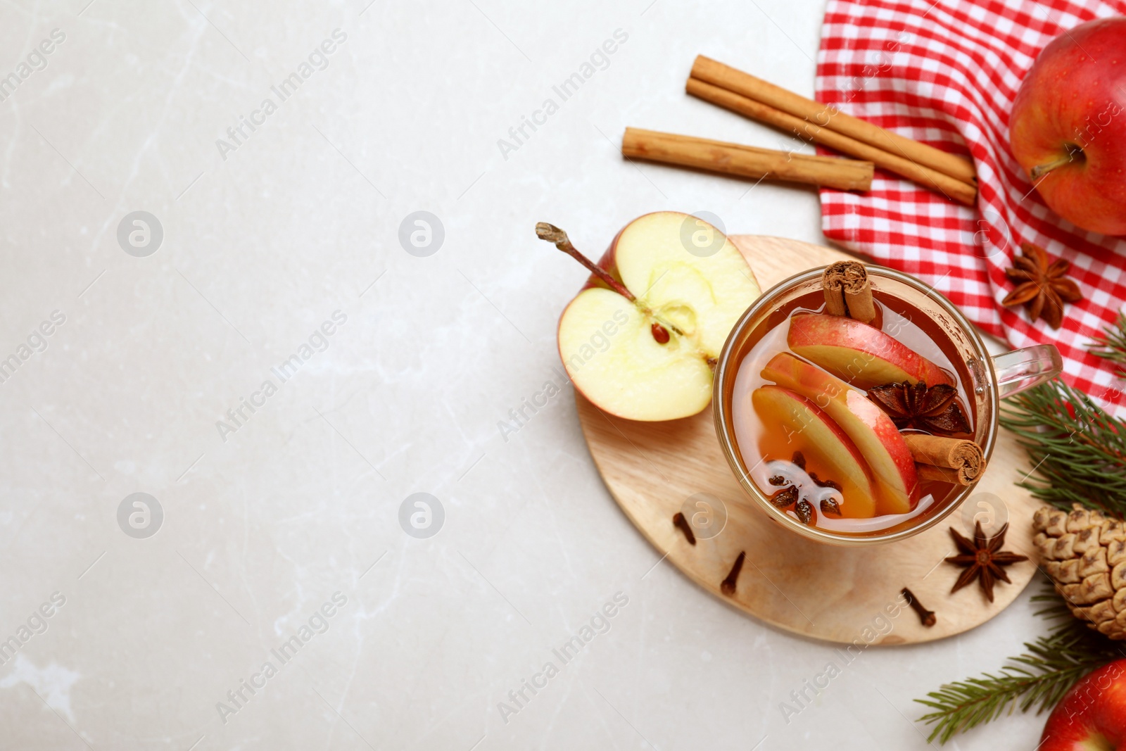Photo of Aromatic hot mulled cider on light grey marble table, flat lay. Space for text