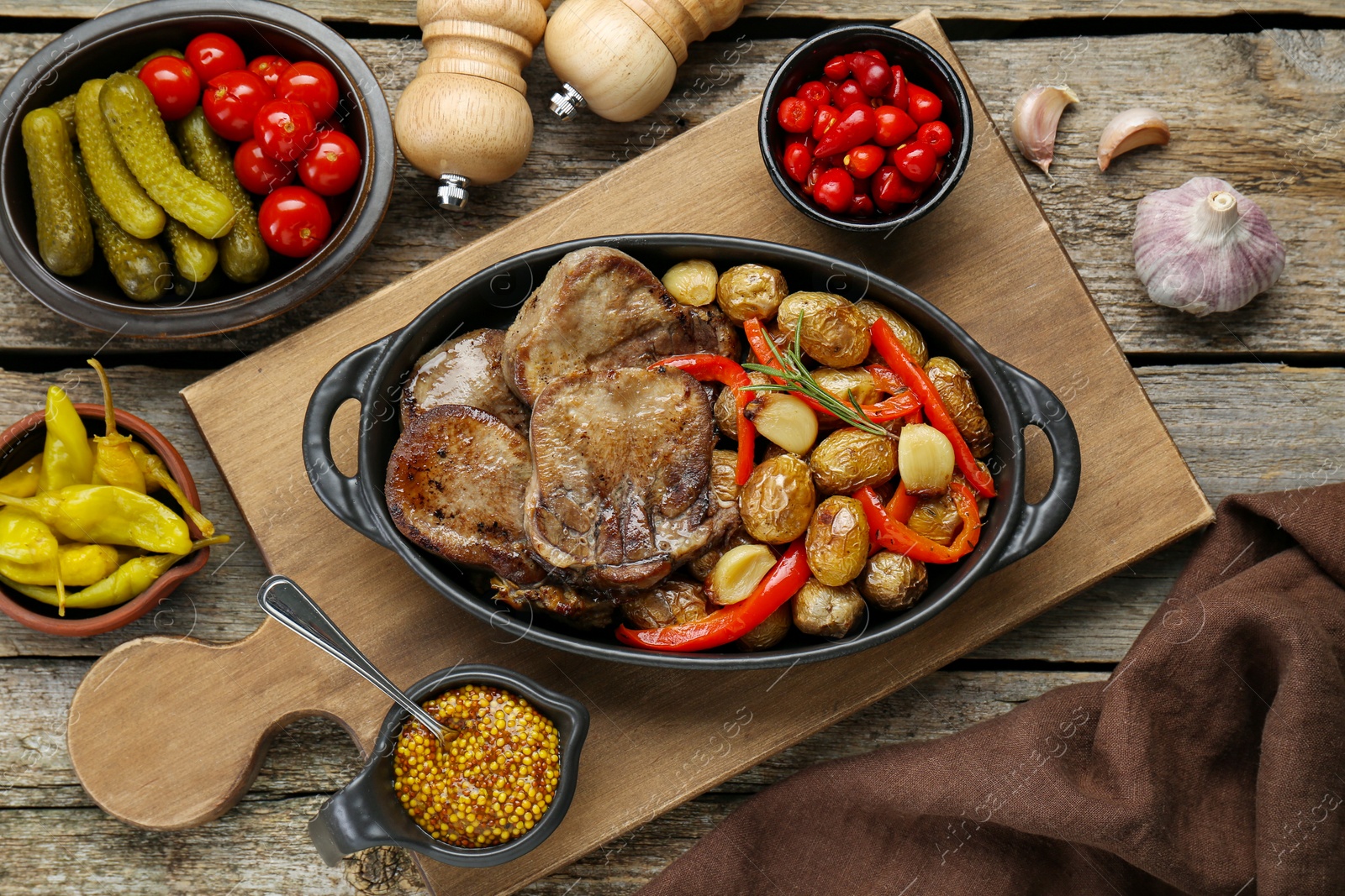 Photo of Tasty beef tongue pieces with potatoes served on wooden table, flat lay