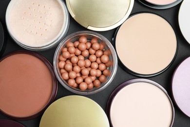 Photo of Different face powders on black table, flat lay