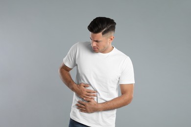 Photo of Man suffering from liver pain on grey background