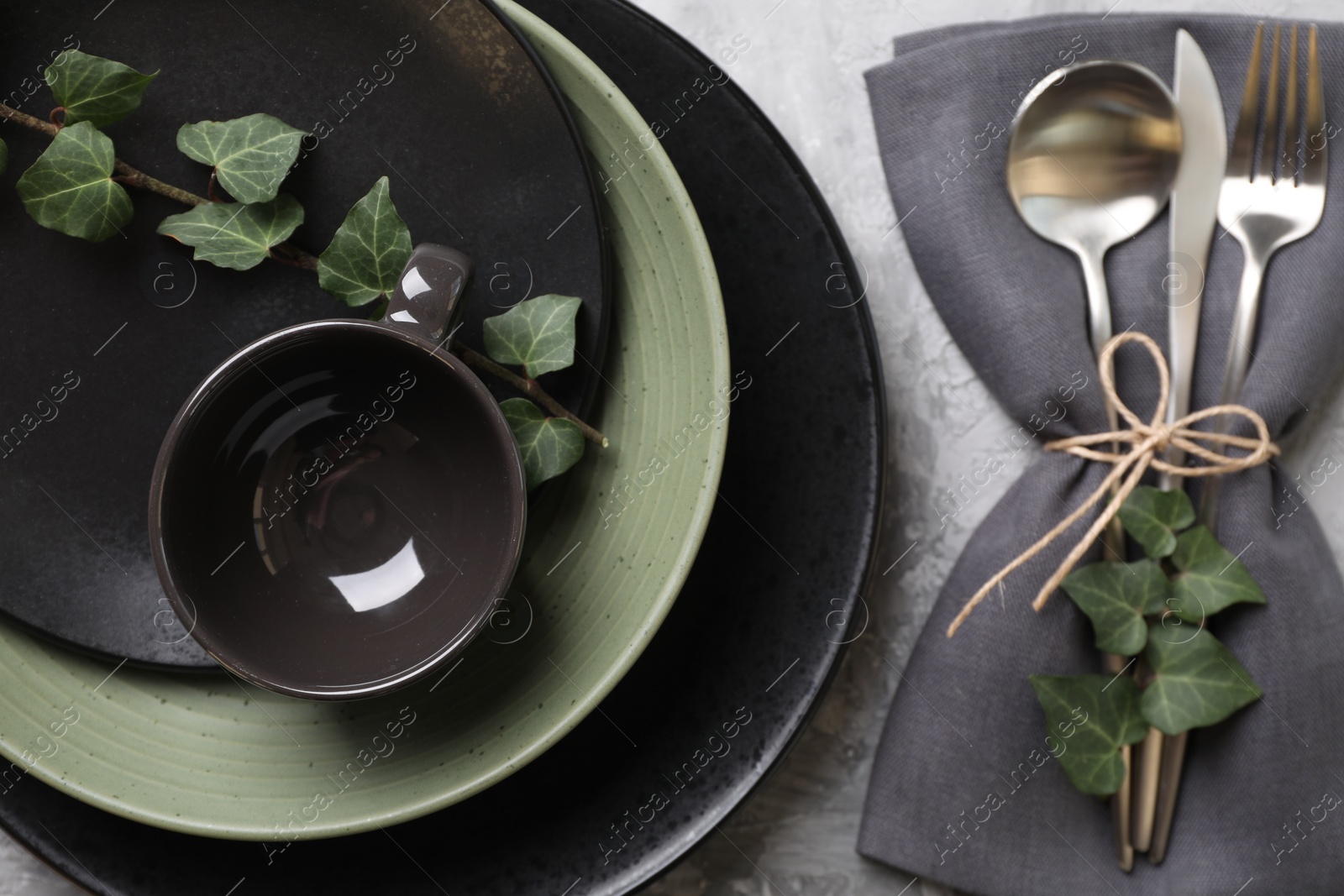 Photo of Stylish table setting. Dishes, cutlery, napkin and floral decor, top view