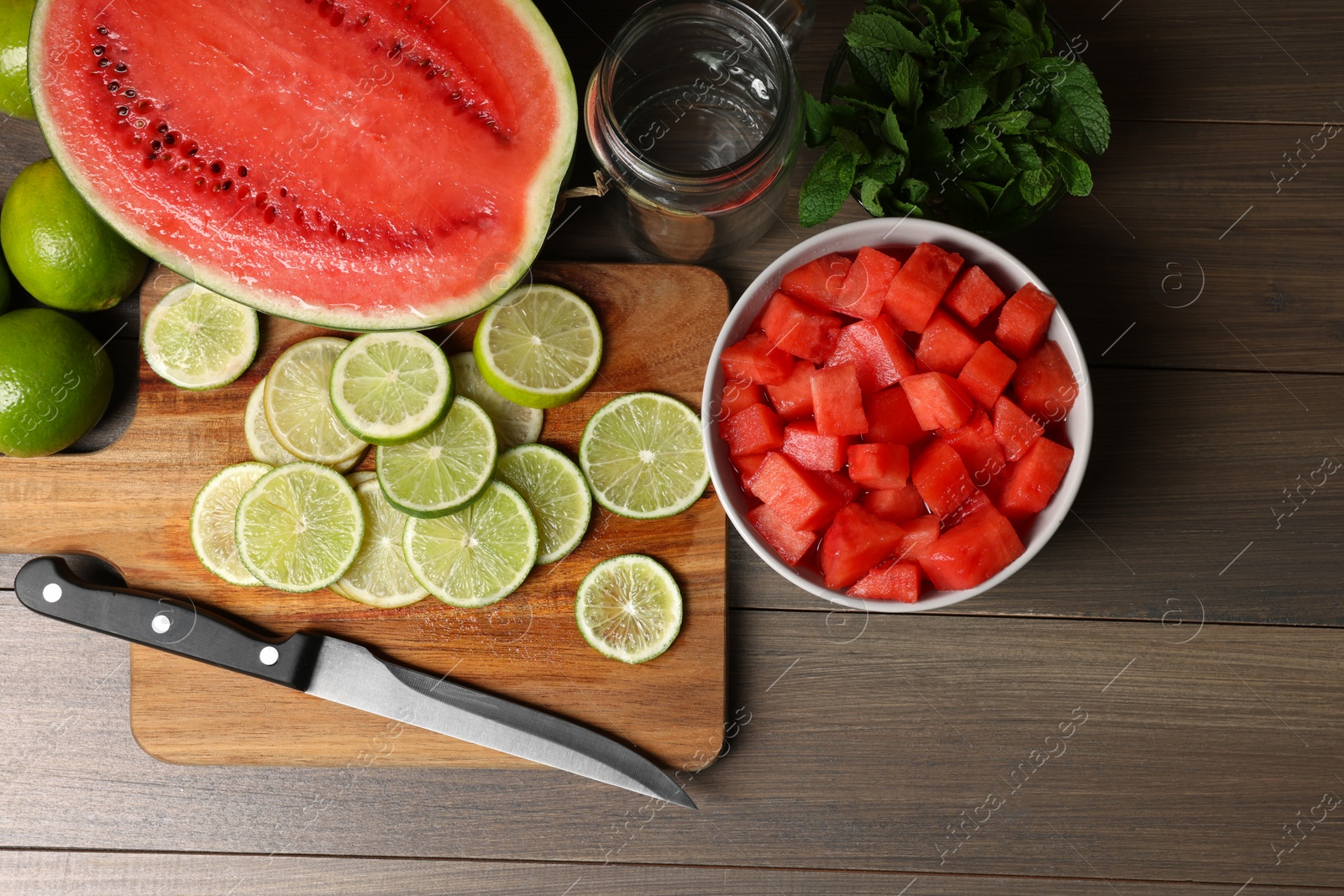 Photo of Fresh ingredients for making watermelon drink with lime on wooden table, above view